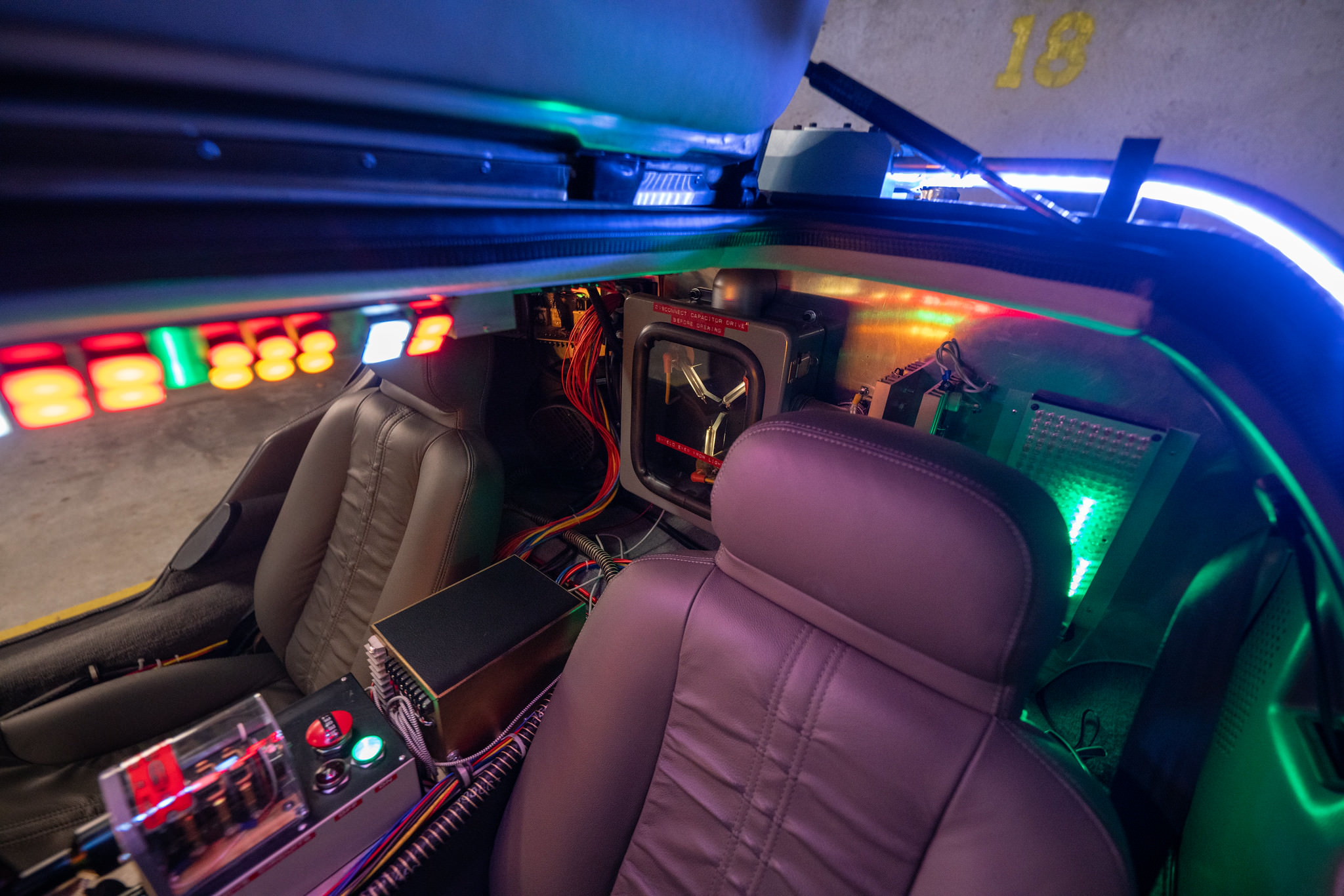 DeLorean 'Time Machine' replica, partial exterior + interior shot: Driver-side gull-wing door, flux bands, time circuit control switch, wiring, flux capacitor and 'christmas tree' LED lights.